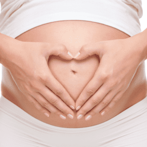 Pregnant tummy with hands making a heart shape